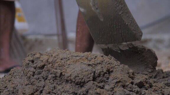 专业建筑工人正在搅拌灰色湿水泥