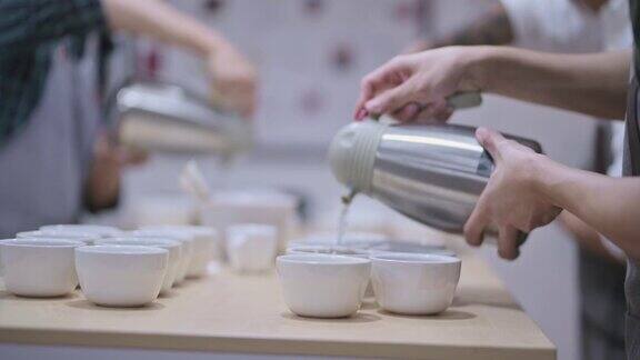 3.专业亚洲华人男咖啡师品级员将热水倒入陶瓷咖啡杯中准备拔火罐咖啡品质测试