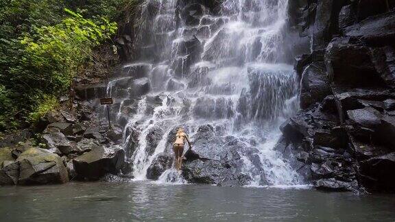 一个年轻女子正在爬瀑布