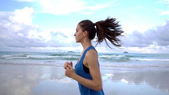 健康活跃的年轻女子在日出时沿着海岸线跑步女性慢跑