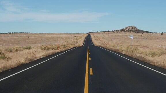 在黑色沥青和黄色线的道路上驾驶在美国沙漠从汽车
