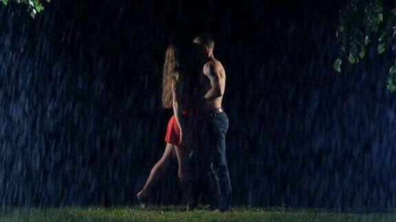 一个女孩和一个男孩在雨中走到一起跳舞