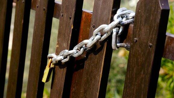 棕色木栅栏金属链和黄色挂锁
