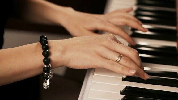 女人的手在弹钢琴女人用手指触摸键盘近距离
