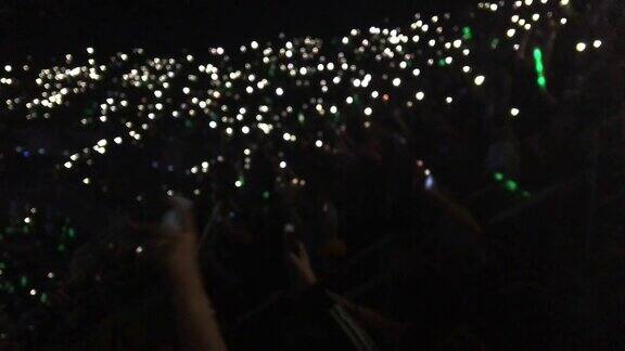人们在音乐厅展示智能手机的灯光