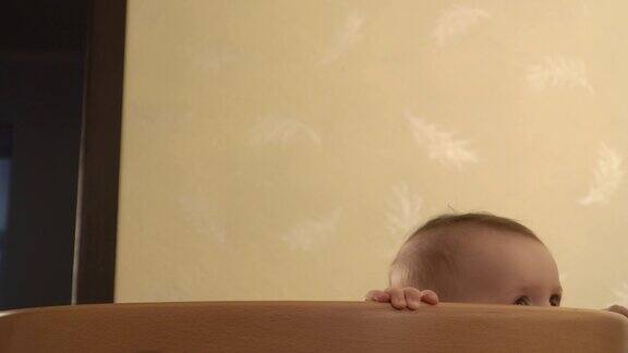 快乐的宝宝站在婴儿床上嘴里叼着奶嘴把奶嘴叼出来然后跳上特写镜头
