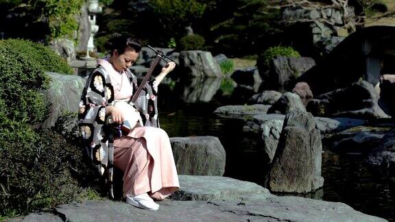 女人在日本花园里玩三味线(视频)