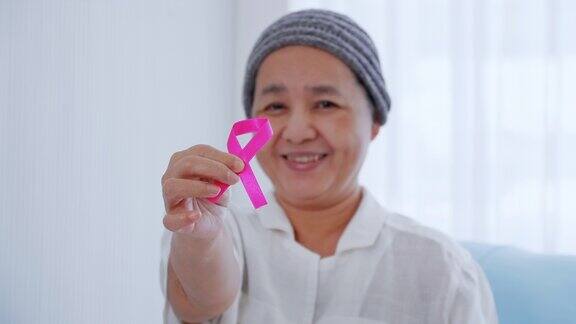 老年女病人在医院拿粉红丝带认识乳腺癌