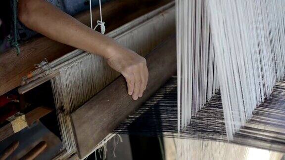 妇女在手工织布机上以传统方式织造丝绸泰国