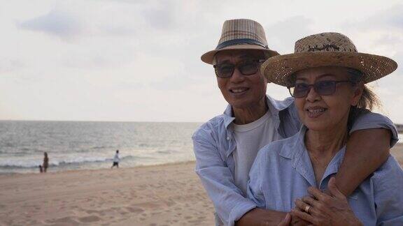 幸福的亚洲老夫妇在海滩上享受