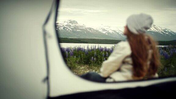 野外露营一个在帐篷里欣赏风景的女人