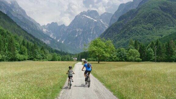 父亲和年幼的儿子骑着他们的自行车上了一个山谷