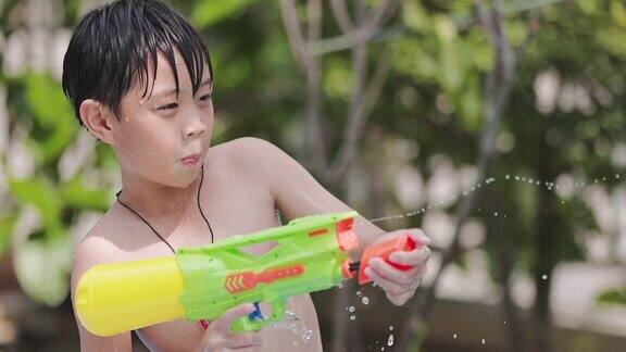 穿着泰国传统服装的孩子们在泼水节玩水枪