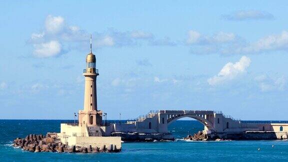 埃及地中海附近的亚历山大港灯塔灯塔前有许多渔船蓝天下