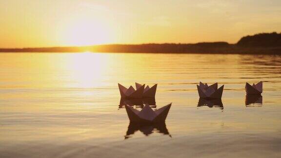 日落时分水面上有几只白色的纸船
