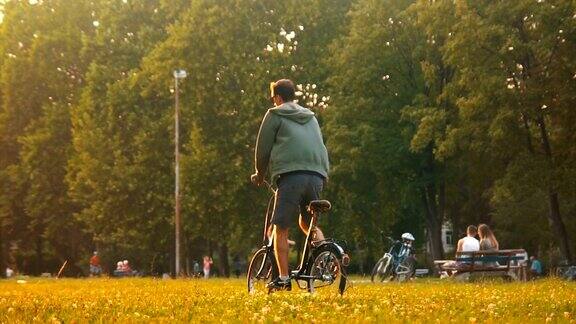 一个在草地上骑自行车的嬉皮士