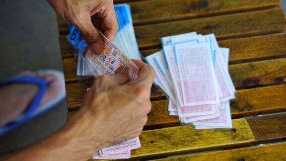 一名亚洲男子把政府彩票装在塑料信封里