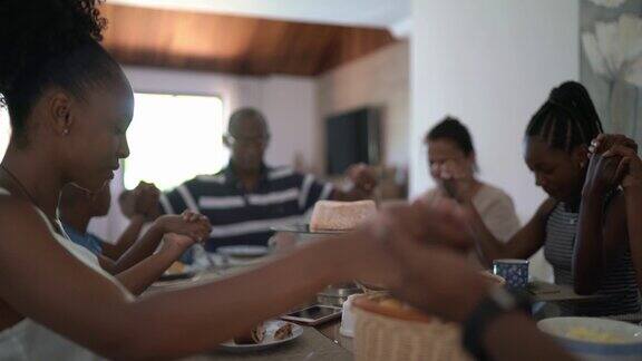 家人在家里吃饭时祷告