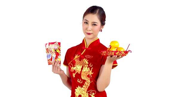 美丽的中国女孩拿着幸运的红包和橘子