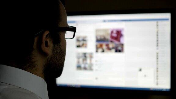 一个用社交网络的人商人读新闻电脑显示器显示模糊的Facebook新闻页面年轻女孩在线