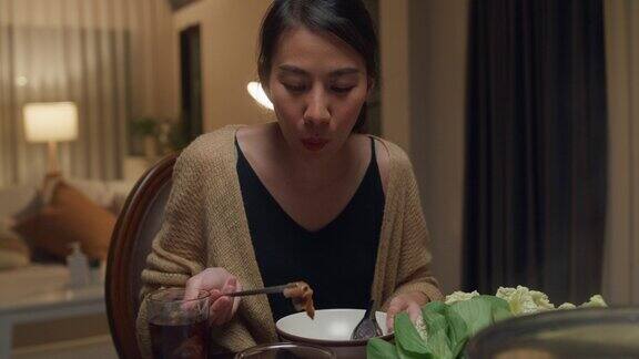 晚上一群快乐的亚洲朋友在家里吃着火锅聚在一起吃春节团圆饭生活方式享受美食