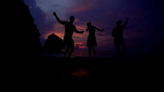 日落在海洋之上朋友们跳舞玩得很开心
