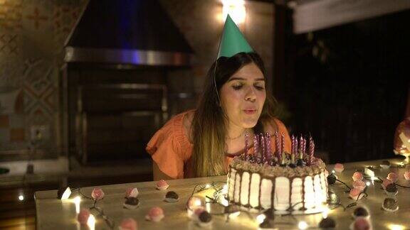 十几岁的女孩吹灭生日蛋糕上的蜡烛