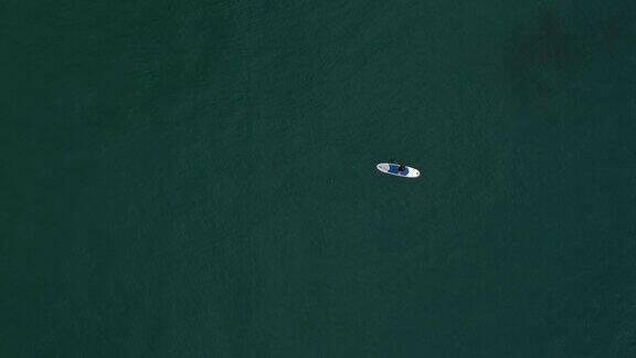一个年轻人在大海里划桨