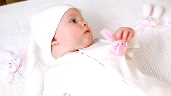 小女孩白色的针织上衣配粉红色的兔子