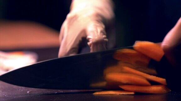 人手戴手套切菜在砧板上用刀切胡萝卜的精准技巧
