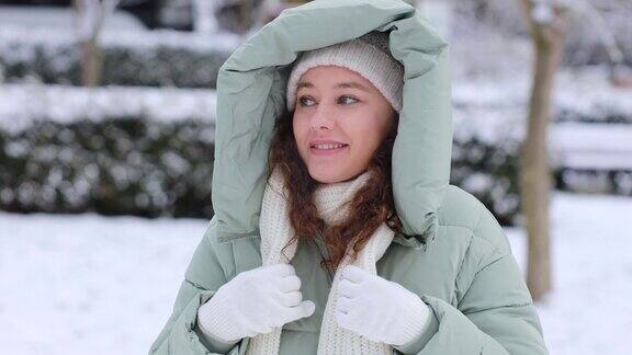 年轻女子在寒冷的雪天穿着暖和的衣服