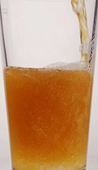 一品脱的啤酒在白色背景下把啤酒倒进玻璃杯的慢镜头