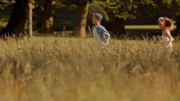 女孩追着一个男孩穿过草地