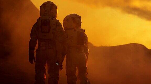 两名宇航员穿着宇航服漫步探索火星红色星球的后视图太空旅行探索和殖民概念