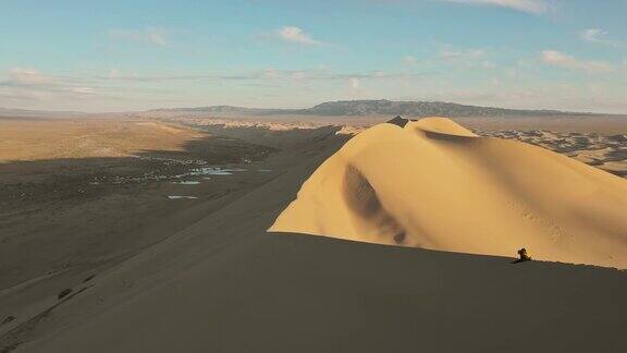 日落时分从沙丘上俯瞰戈壁沙漠的人的鸟瞰图