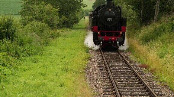 一列老式蒸汽火车正向摄像机驶来