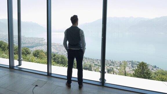 成功的年轻商人在现代化的大厅房间与窗口俯瞰城市湖全景思考未来的职业想法