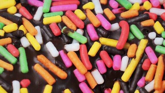巧克力甜甜圈与彩色糖浇头闭合慢动作