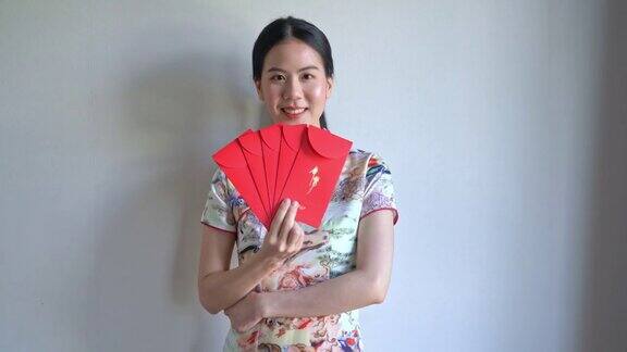 美丽的亚洲妇女穿着带有红包的中国传统服装