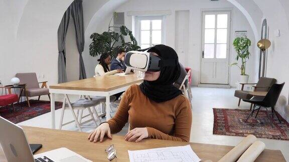年轻的中东女商人在办公室戴着虚拟现实眼镜