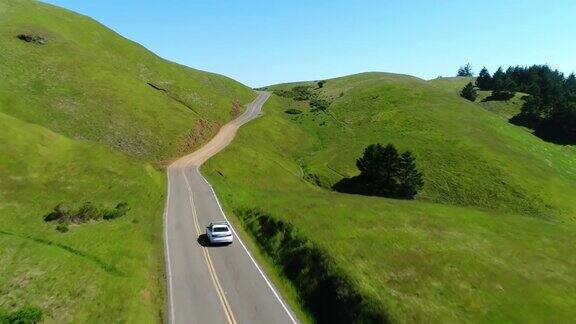 鸟瞰图的汽车驾驶下的乡村道路通过起伏的山