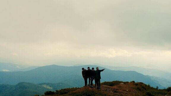 四个朋友站在山顶上