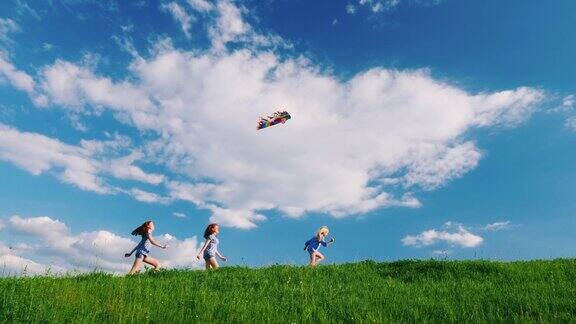有趣而无忧无虑的孩子们跑过绿色的草地玩着风筝快乐的童年