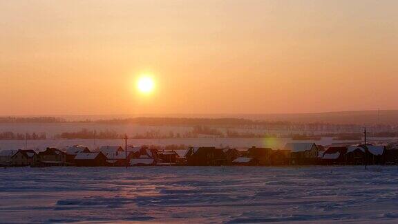 日出在冰雪覆盖的俄罗斯乡村景观远摄