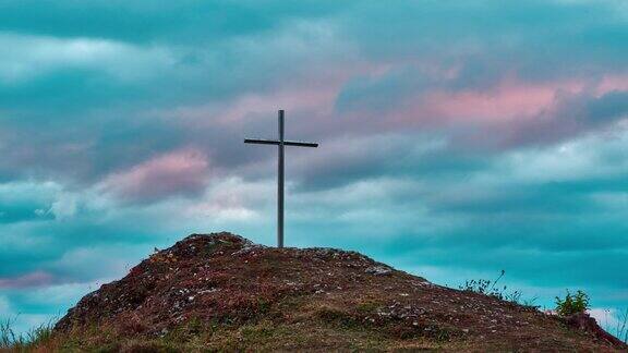 矗立在岩石山上的十字架夕阳下五彩缤纷的云朵4k
