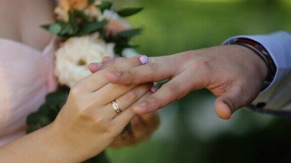 新娘把结婚戒指戴在新郎的手指上新婚夫妇在婚礼上交换结婚戒指