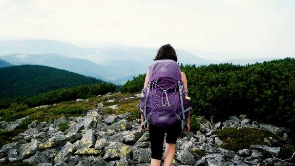 女子徒步旅行与背包看风景的山