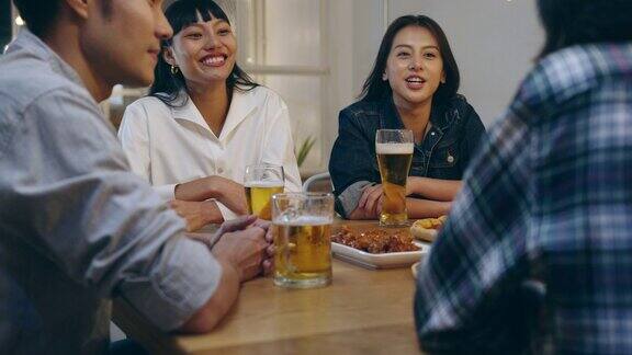 一群快乐的游客年轻的亚洲朋友在考山路的夜店里喝着啤酒开心地笑着