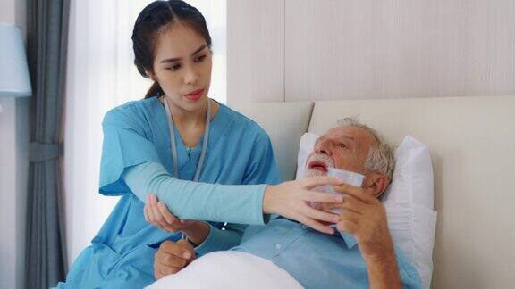 女医生在病床上为老年病人讲解处方药
