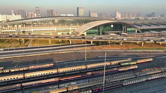 无人机高视角的高速公路交通与邦苏车站是一个新的铁路枢纽与快速列车日落场景在曼谷泰国
